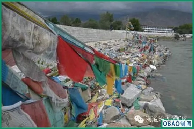 挂在石笼护岸上的经幡，失去了表达的自然载体